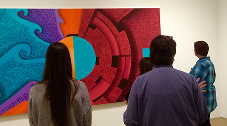 Students looking at artwork on the wall.