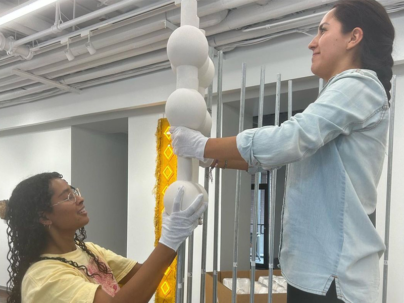 2 women setting up an art exhibit
