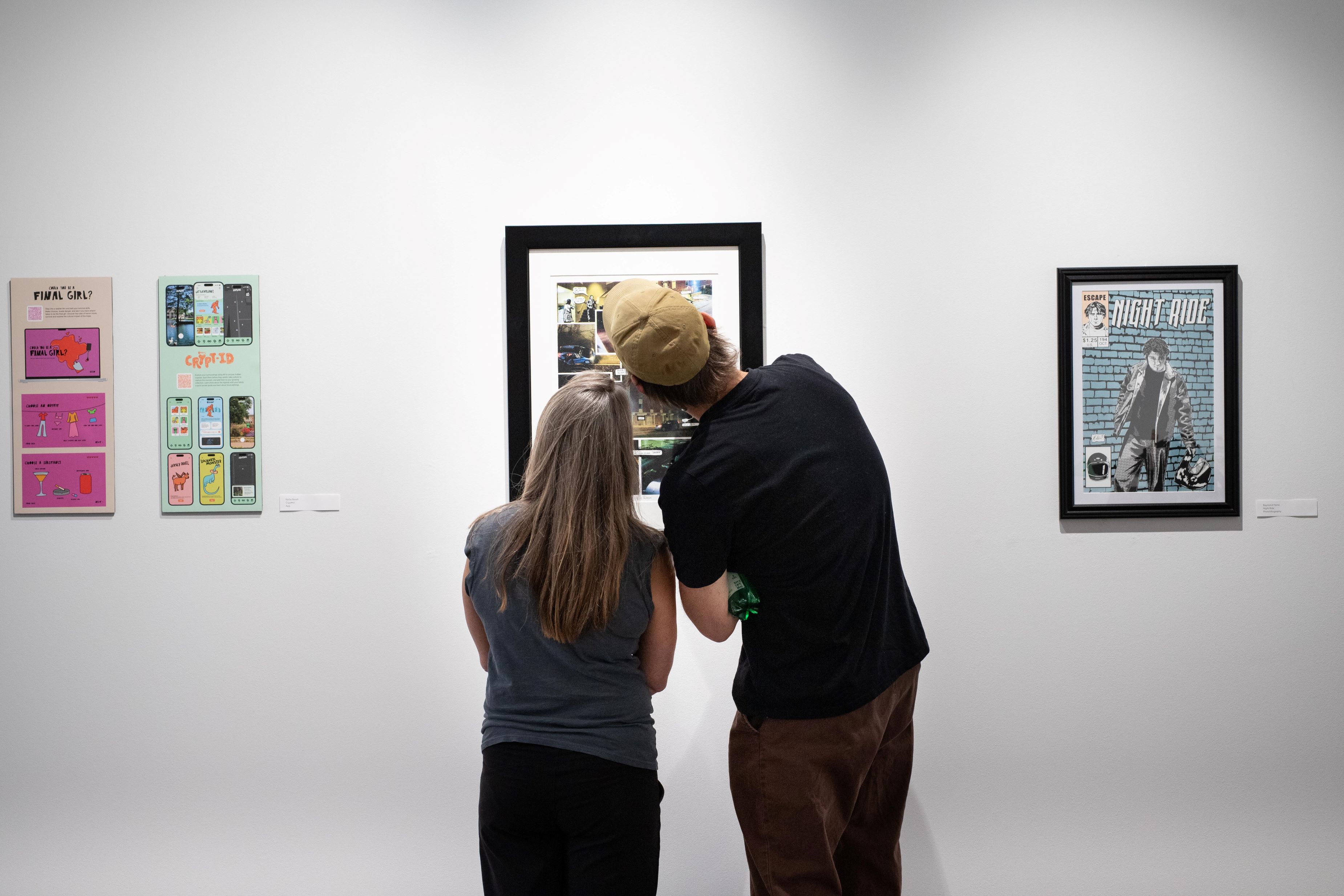 Image of two people looking at artwork viewed from behind