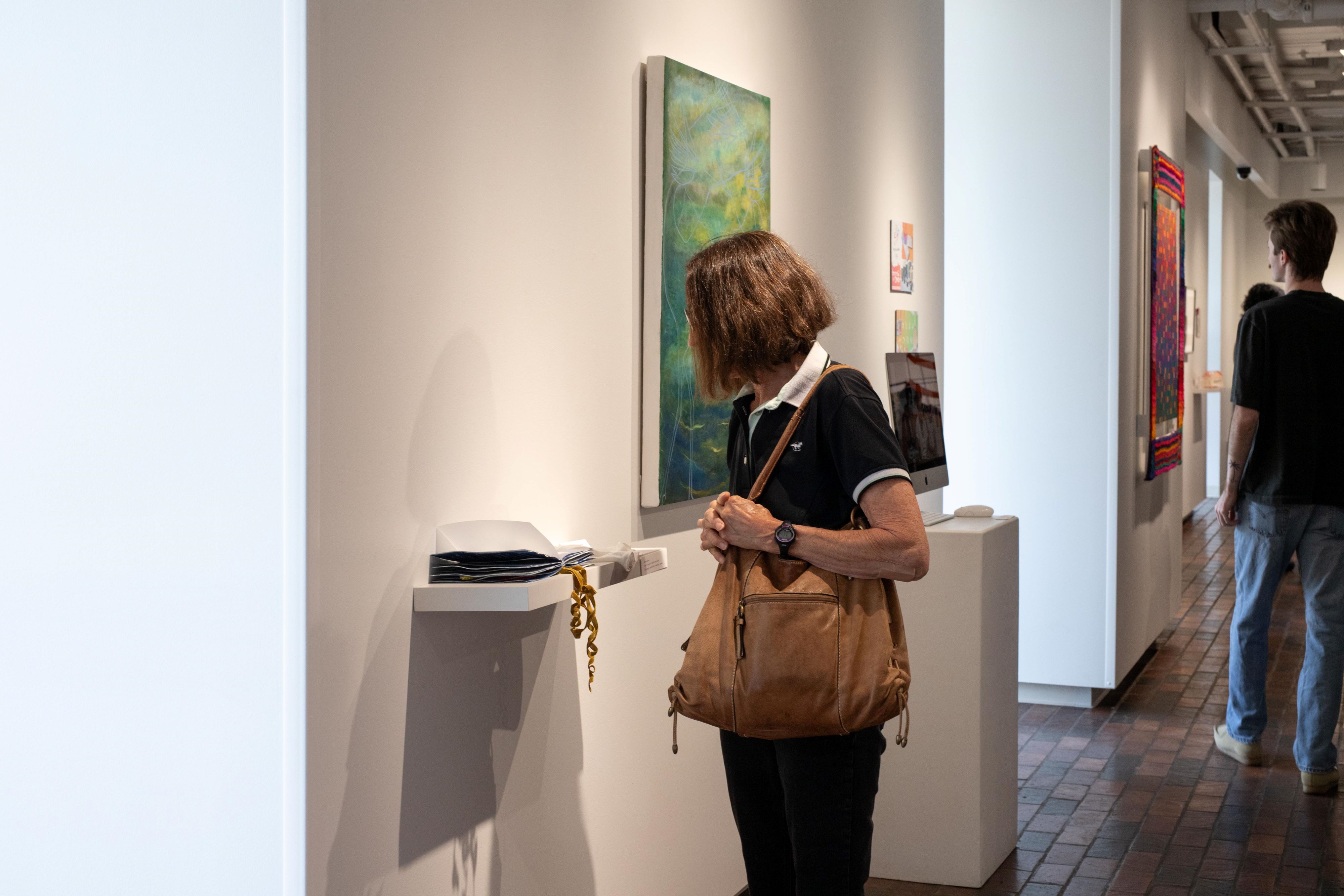 Person from the side looking down at an art book