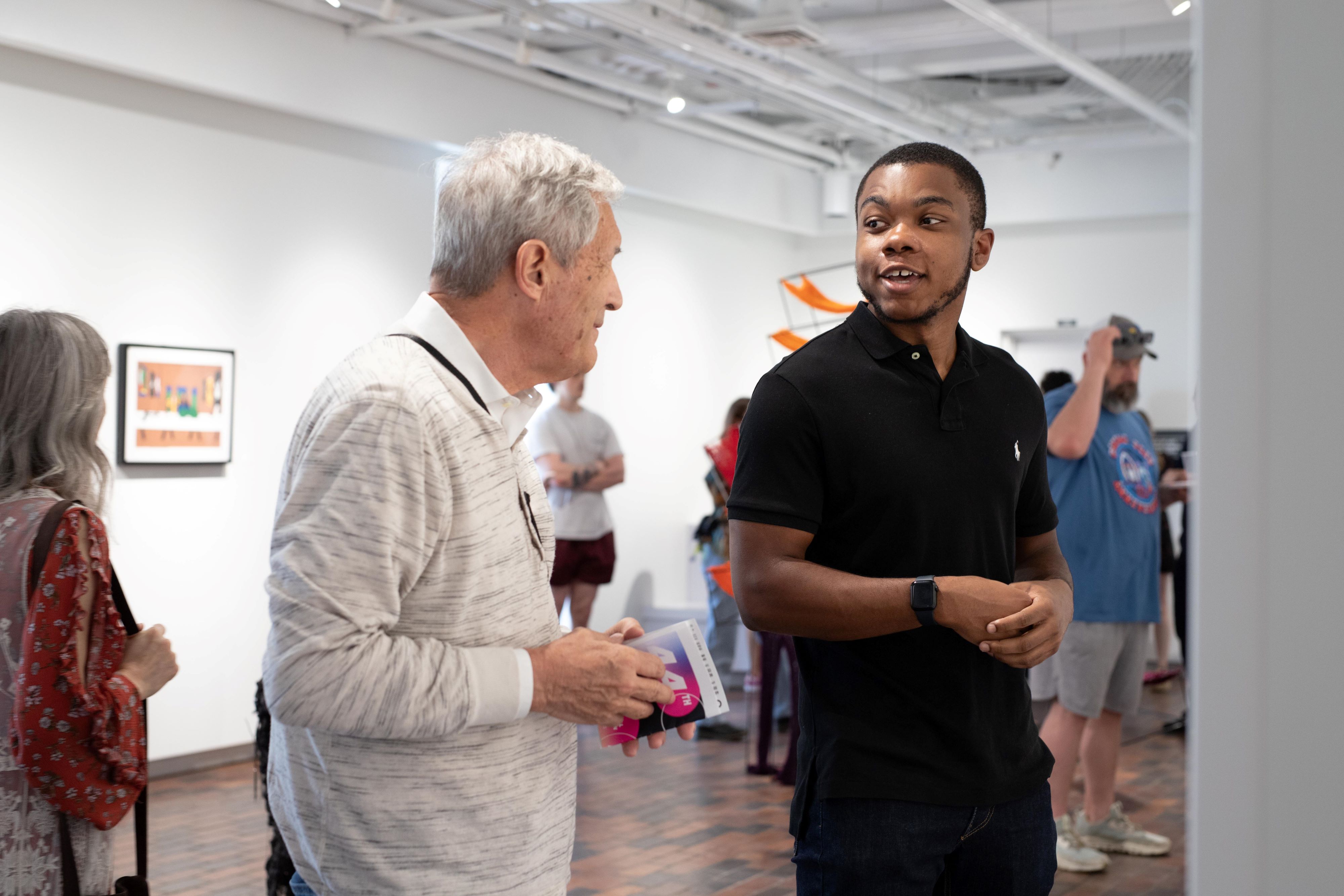 Student award winner talking with reception attendee