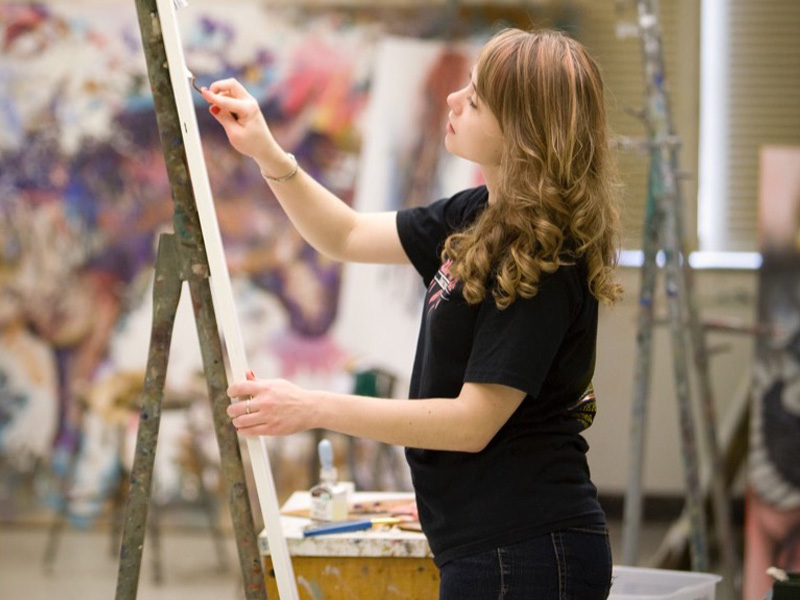 Student is painting on an canves.