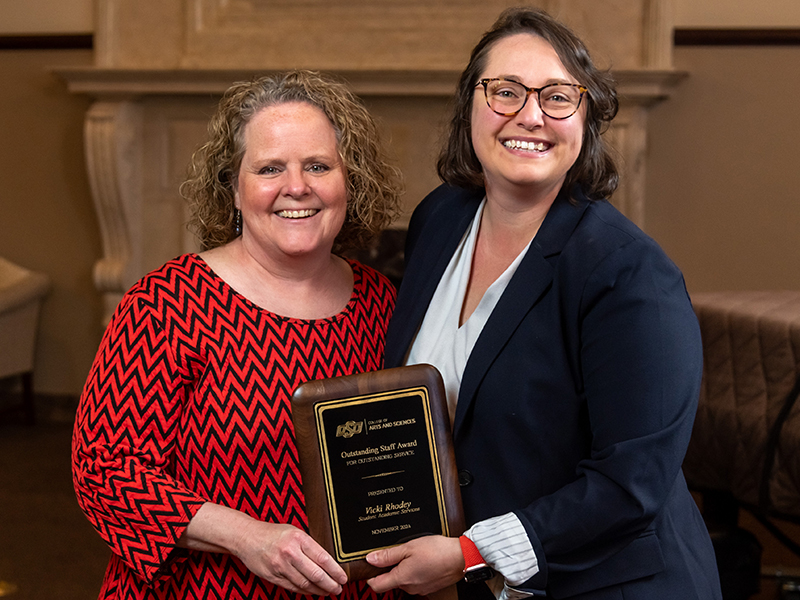 Vicki Rhodey receiving her award from Dean Cro
