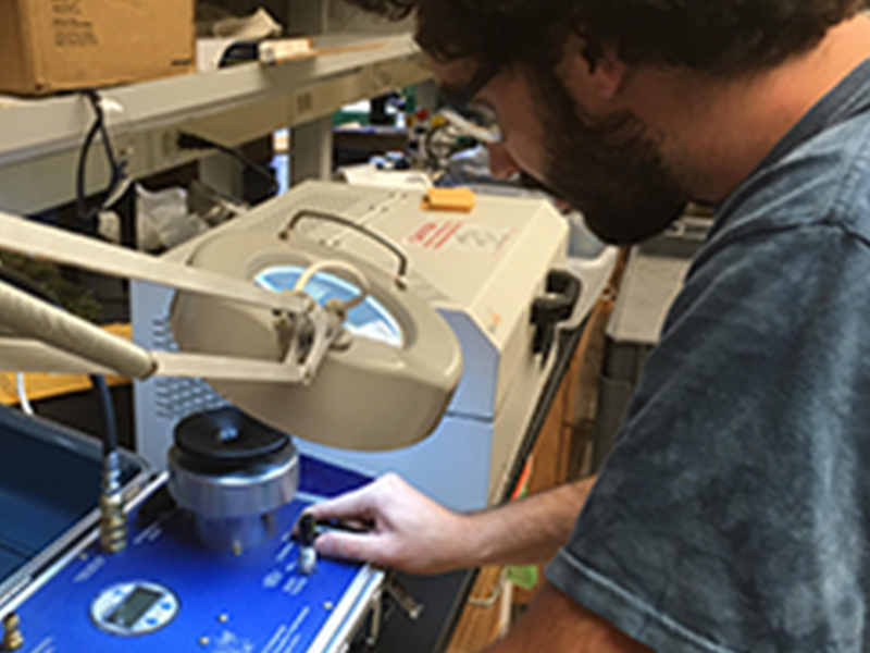 Male student looking through magnifying glass
