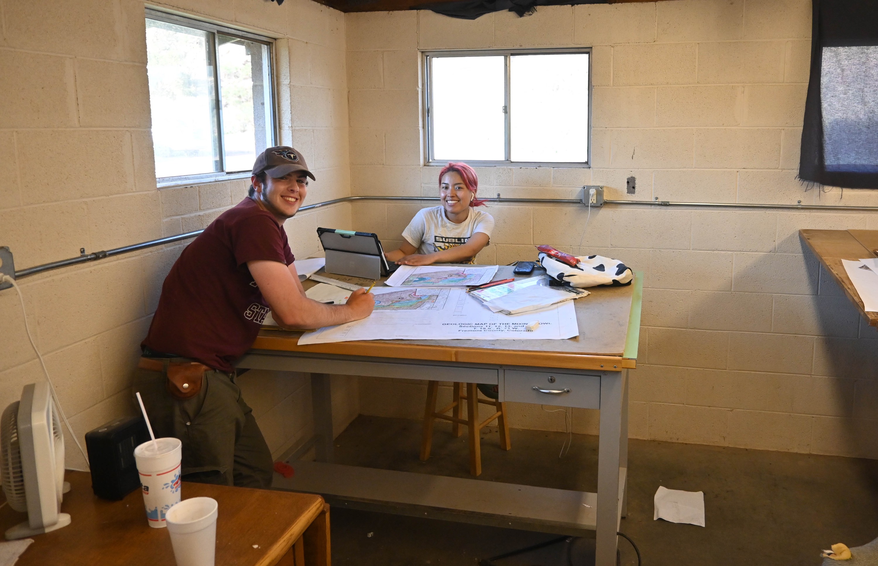 A male and female student sitting at a table working on maps. A male and female student sitting at a table working on maps.