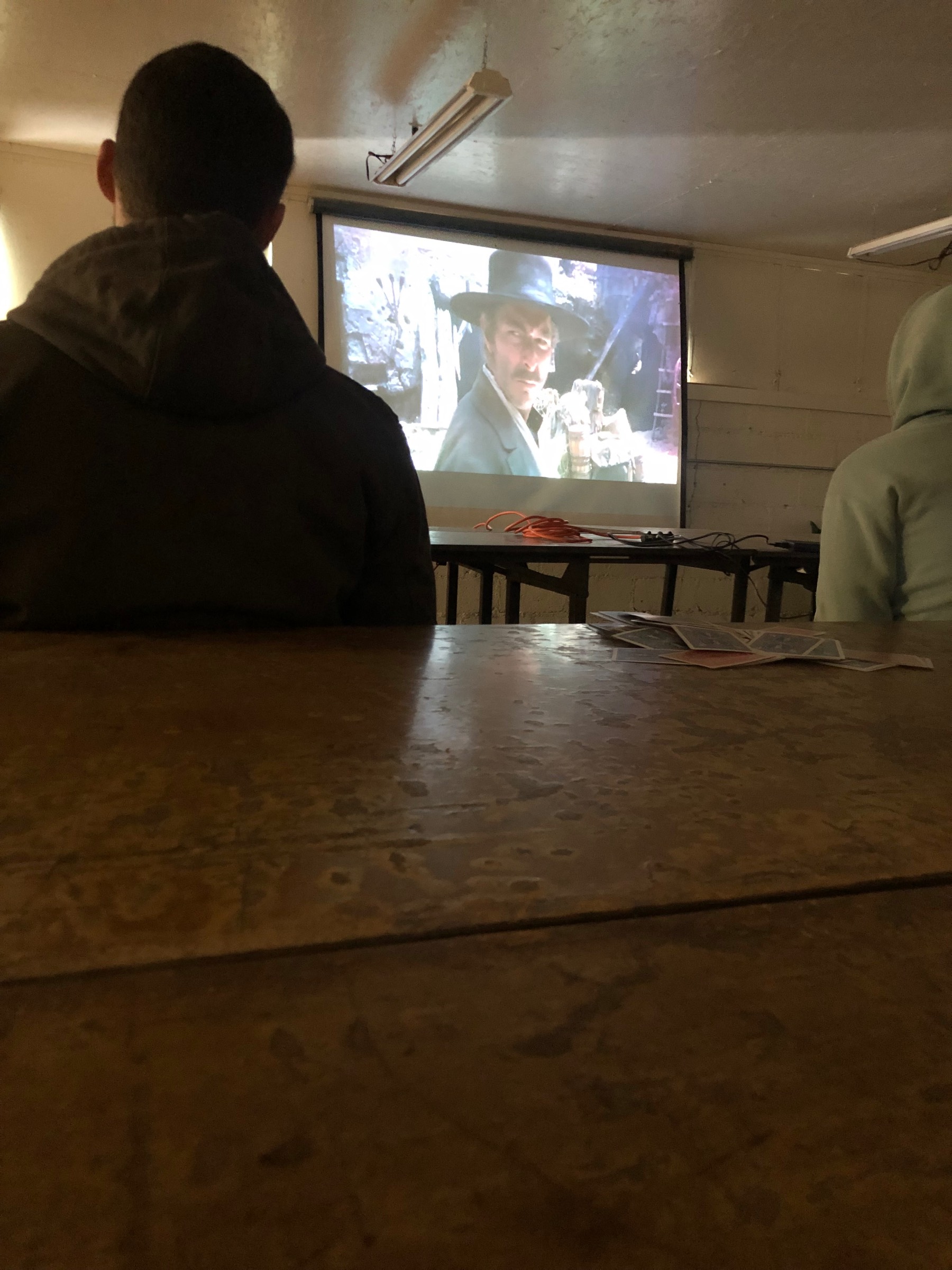Students watching a movie on a projector in the dining hall. Students watching a movie on a projector in the dining hall.