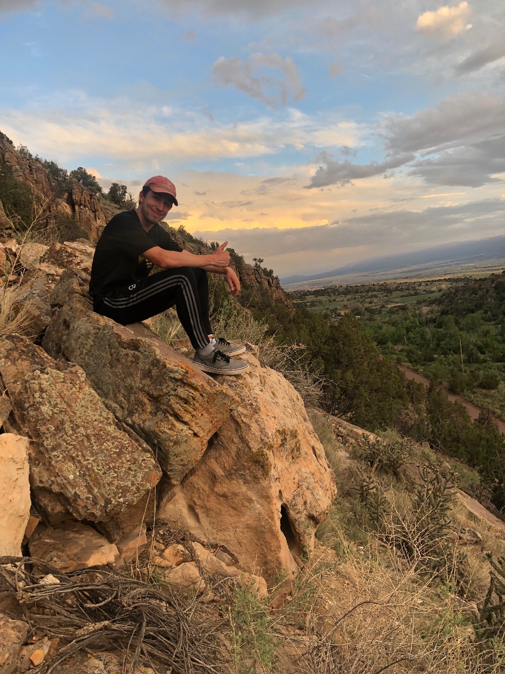 Student Jacob sitting on a rock watching the sunset on a hike in the hogback. Student Jacob sitting on a rock watching the sunset on a hike in the hogback.