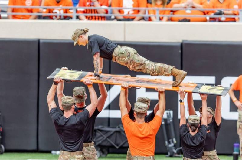 a cadet does pushups at a football game