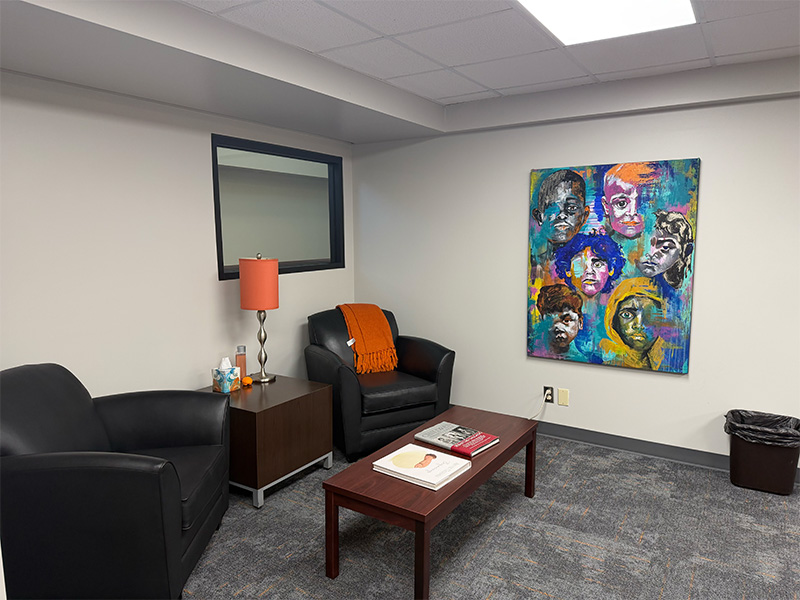 Interior of a room with couches, a coffee table, and artwork on the wall.