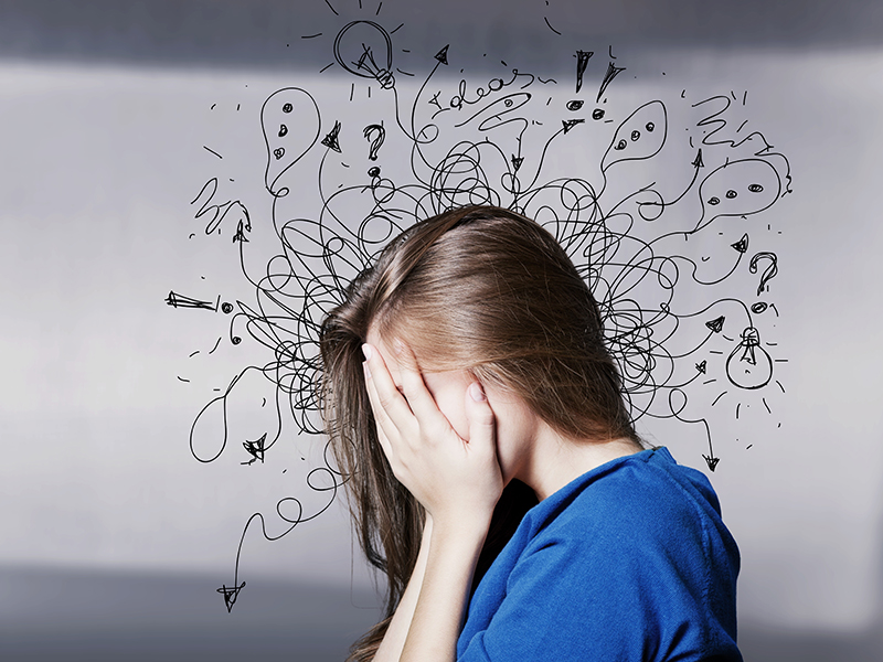 woman covering her face with squiggles around her head representing anxiety