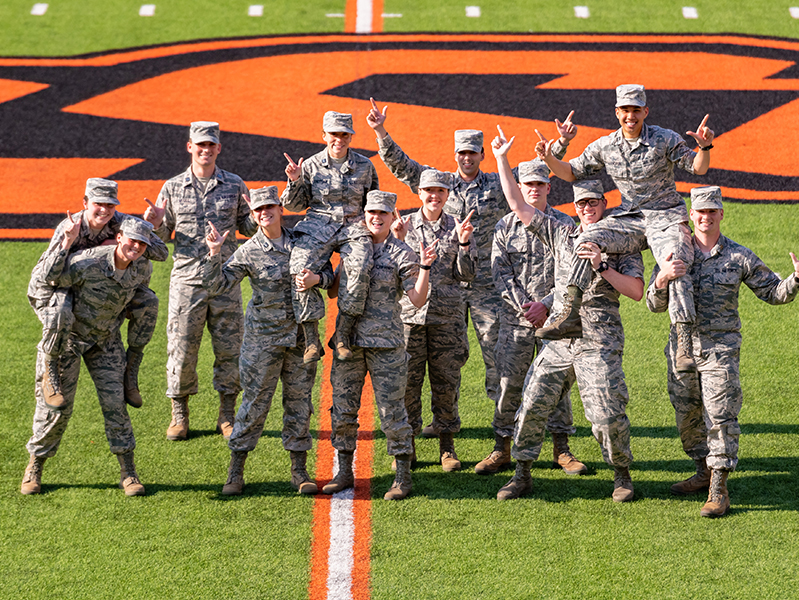 aerospace_rotc_gopokes.jpg ROTC Cadets in the middle of a football field with Go Pokes signs