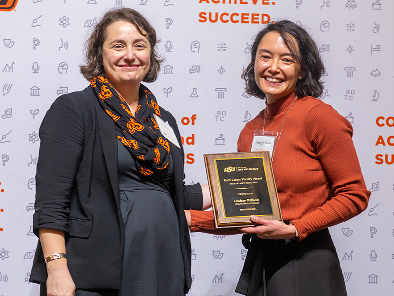 Winner Lindsay Wilhelm holding her award on stage with Dean Cro Winner Lindsay Wilhelm holding her award on stage with Dean Cro