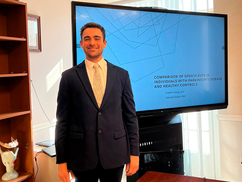 Zeke Young in front of monitor defending his thesis