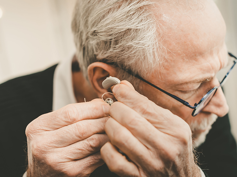 Man putting on hearing aids