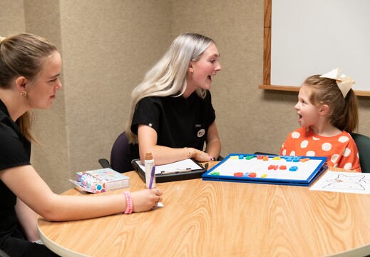Two SLP grad students work with a client.