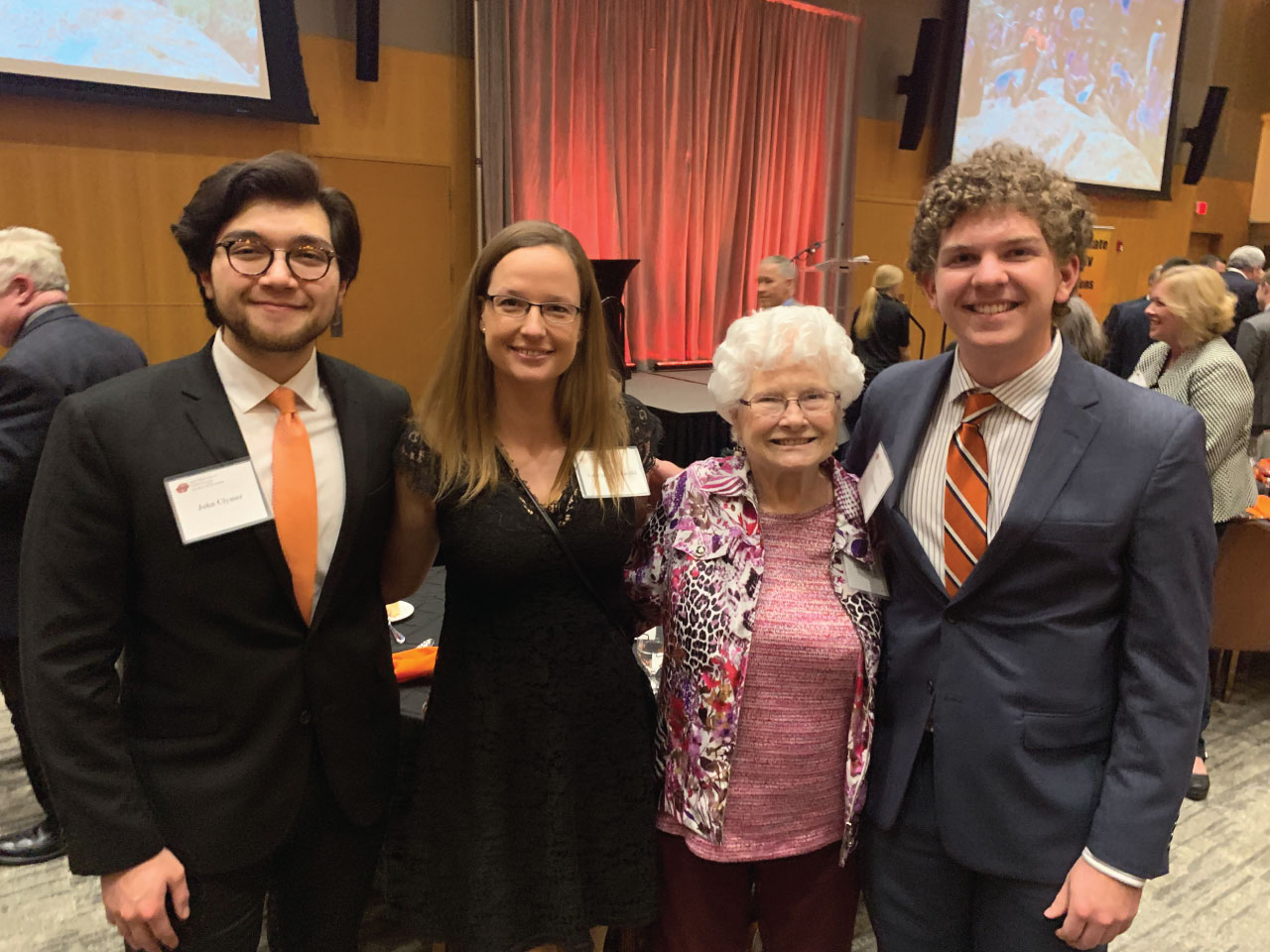 Three students and a donor at an awards banquet.