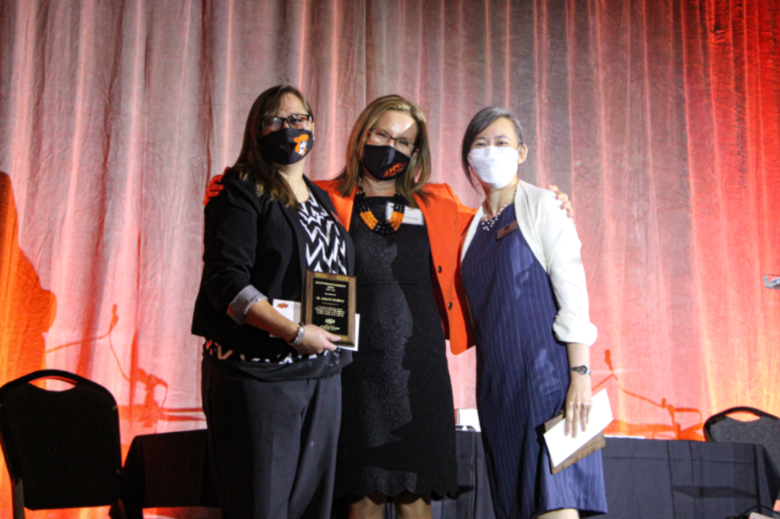Dr. Ashley Burkett, Dr. Camelia Knapp and Dr. Tracy Quan posing on stage together for a picture.