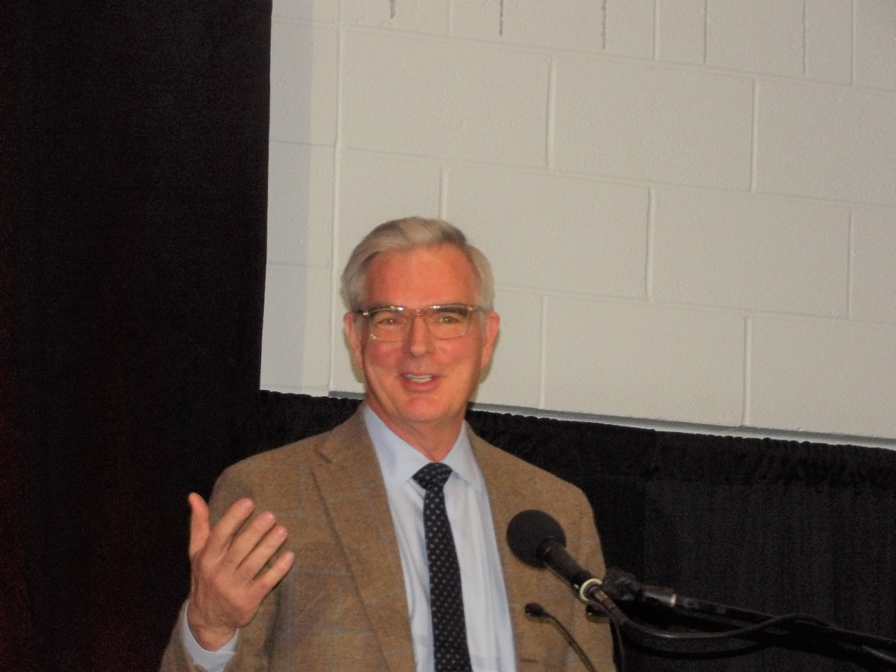 Dr. Erik Oswald at podium making a speech.