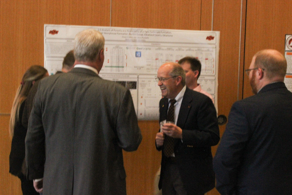 Dr. Jim Puckette laughing with students before banquet.