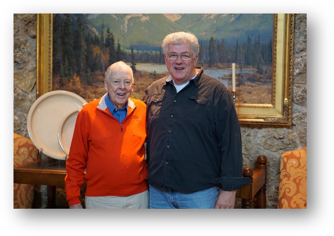 Mr. Boone Pickens standing with Mr. Mike Kuykendall in front of a landscape painting waiting for their picture to be taken.