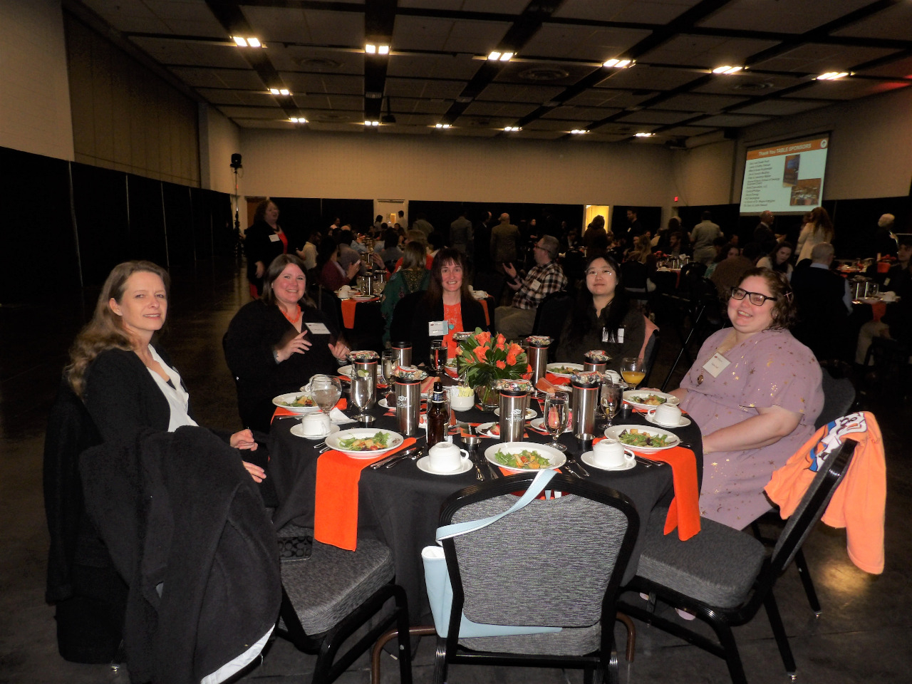 Dr. Natascha Riedinger, Dr. Michelle Abshire, Ms. Lauren Haygood, Ms. Wei Ren and Ms. Elaine Duff sitting together at dinner table visiting.