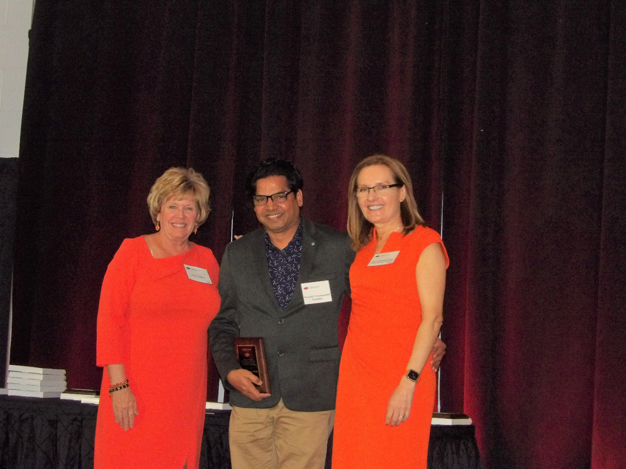 Mrs. Patty Walker and Dr. Camelia Knapp presenting an award to Mr. Sreejesh Seedhar.