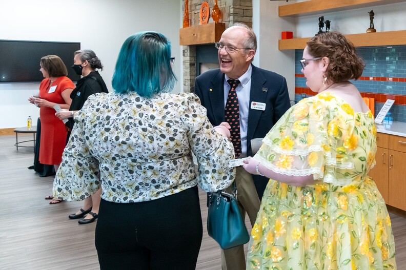 Jim Puckette, Elaine Duffy and her guest catching up in the silent auction room.
