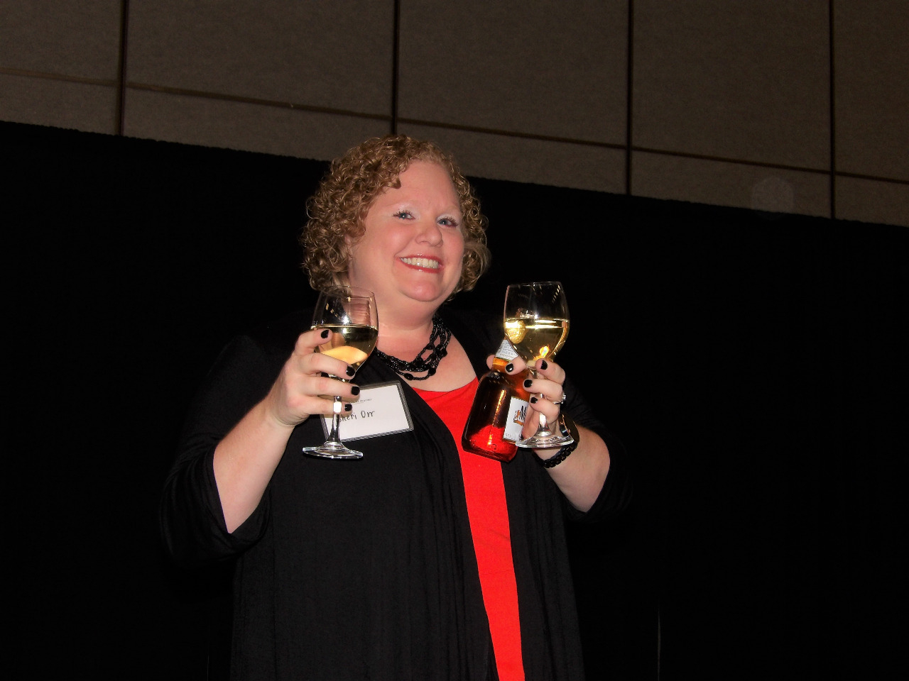 Mrs. Sheri Orr smiling away while enjoying a glass of wine.