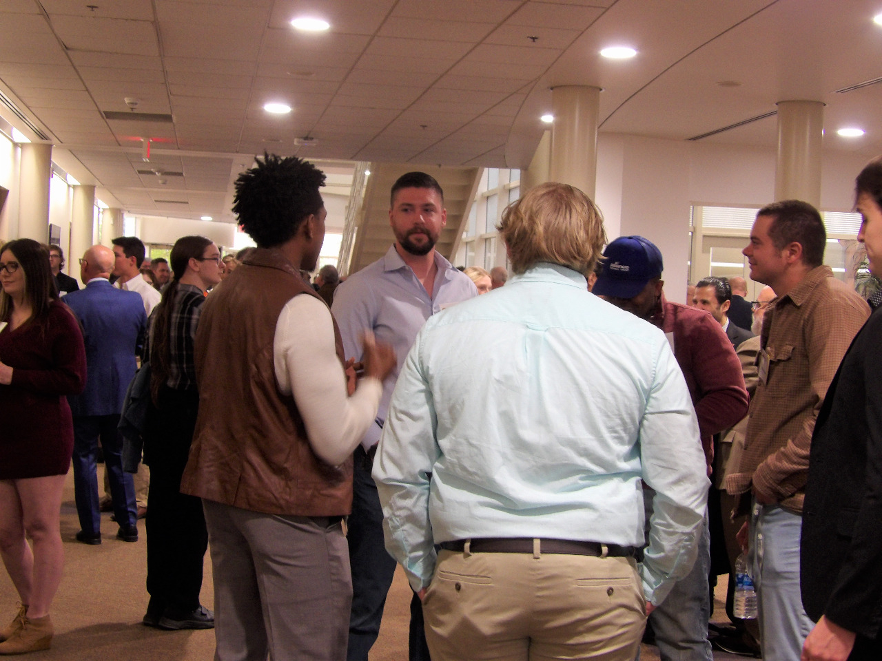 Room full of people visiting before banquet begins.