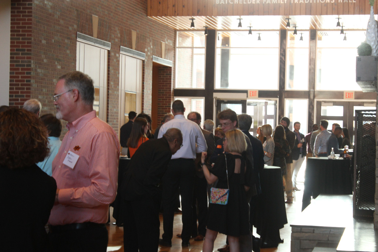 Faculty, alumni and students visiting in groups before banquet begins.