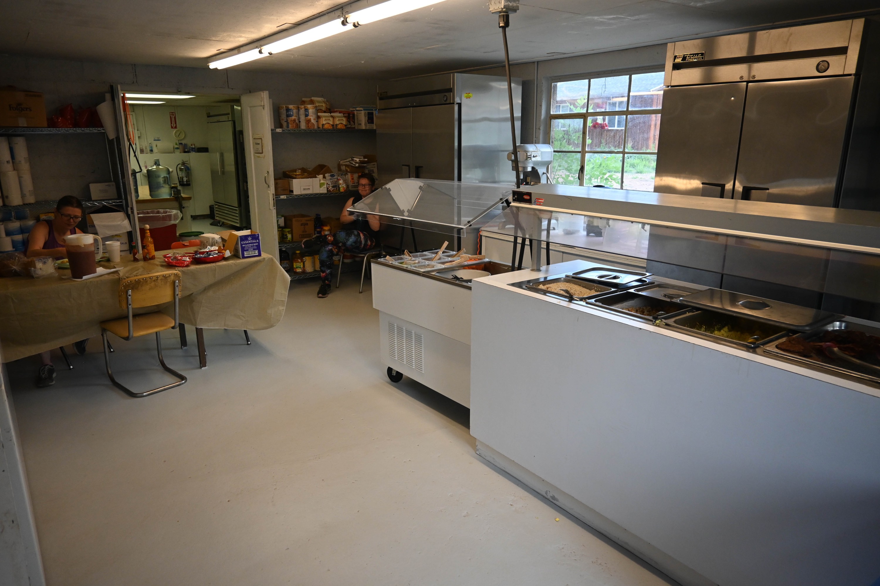 Two people relaxing between serving meals in the dining hall. Two people relaxing between serving meals in the dining hall.