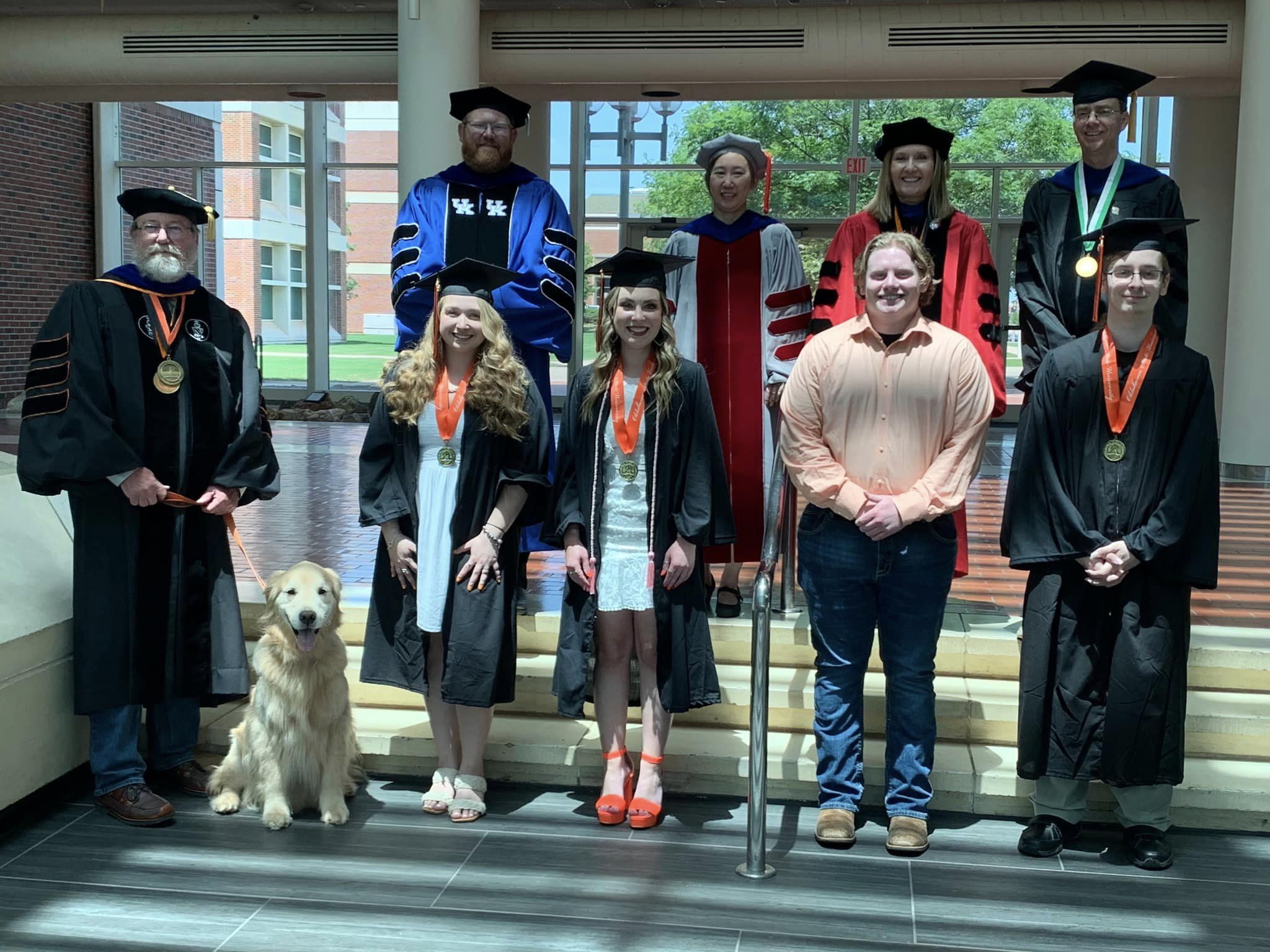 A group of garduate students with their faculty advisors in their caps and gowns. A group of garduate students with their faculty advisors in their caps and gowns.
