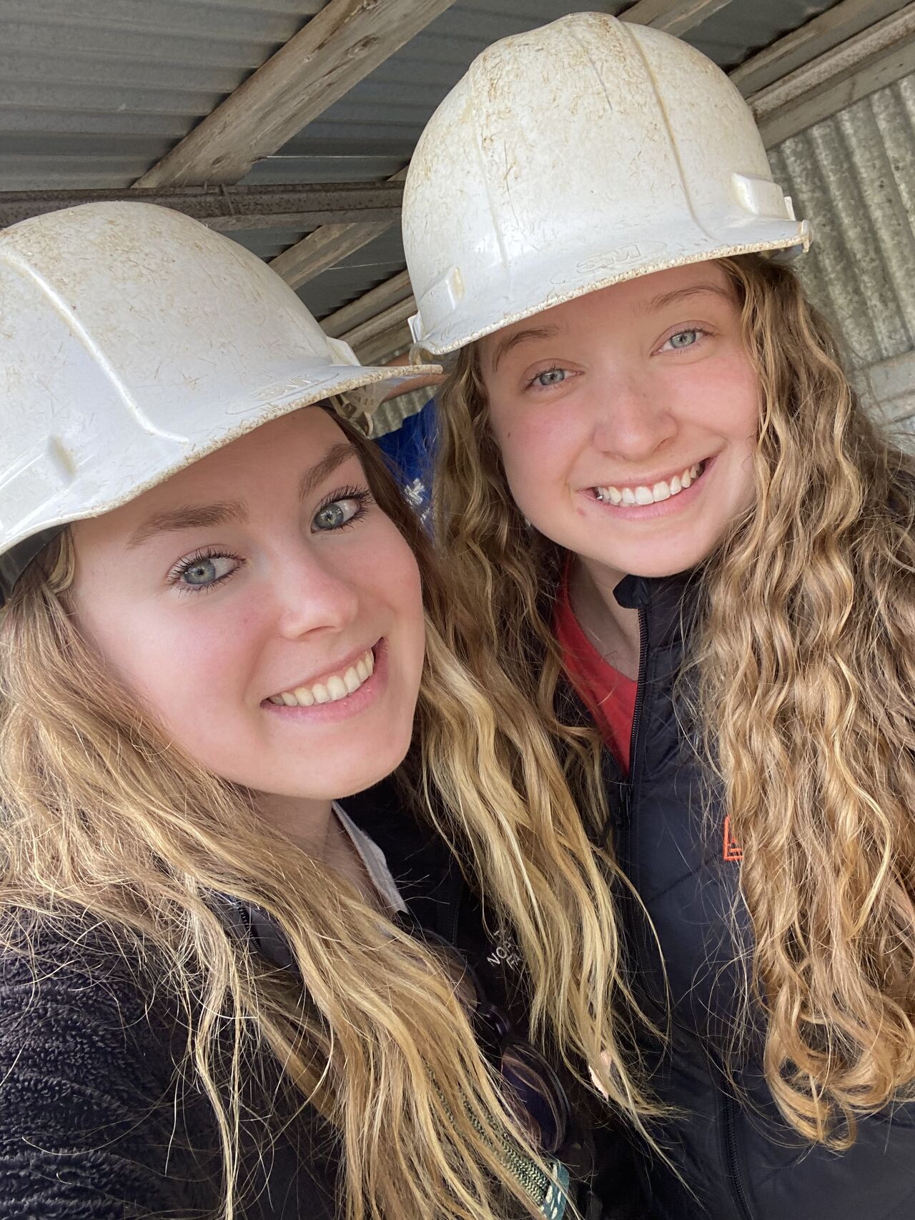 Students Izabelle and Megan wearing hard hats posing for a photo.