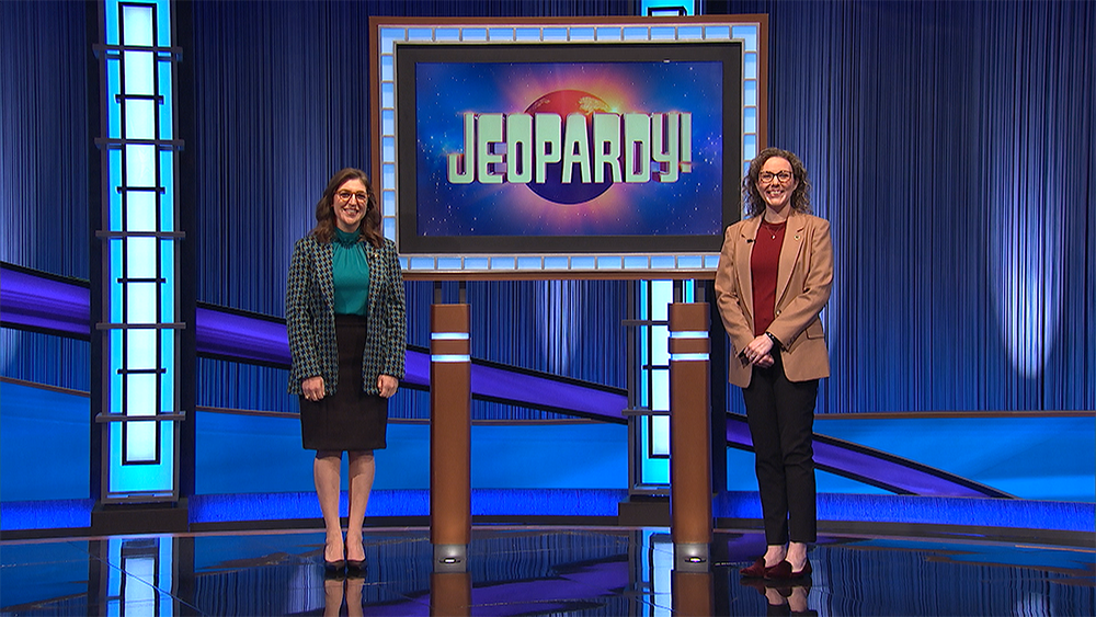 Two women standing in front of a Jeaopardy screen.