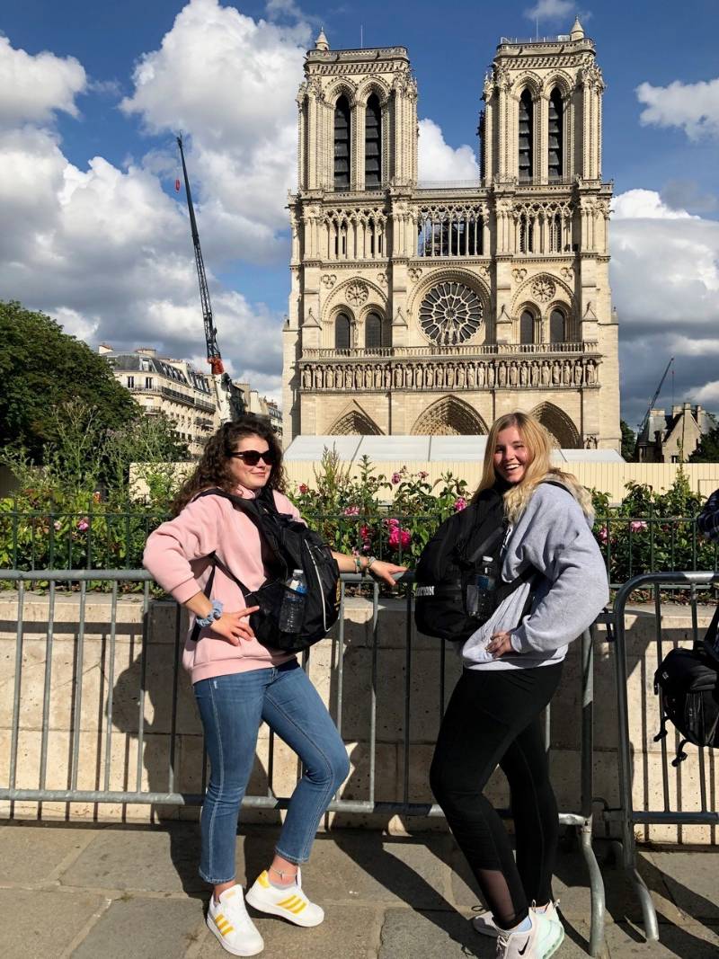 Two students standing in front of a building Two students standing in front of a building
