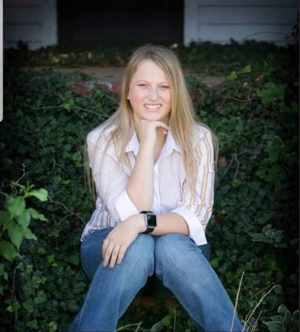 bnutter.jpg A woman with blonde hair poses in front of a natural background.