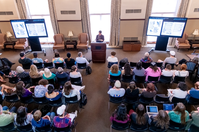 Balcony view of Doyle presenting to an audience Balcony view of Doyle presenting to an audience