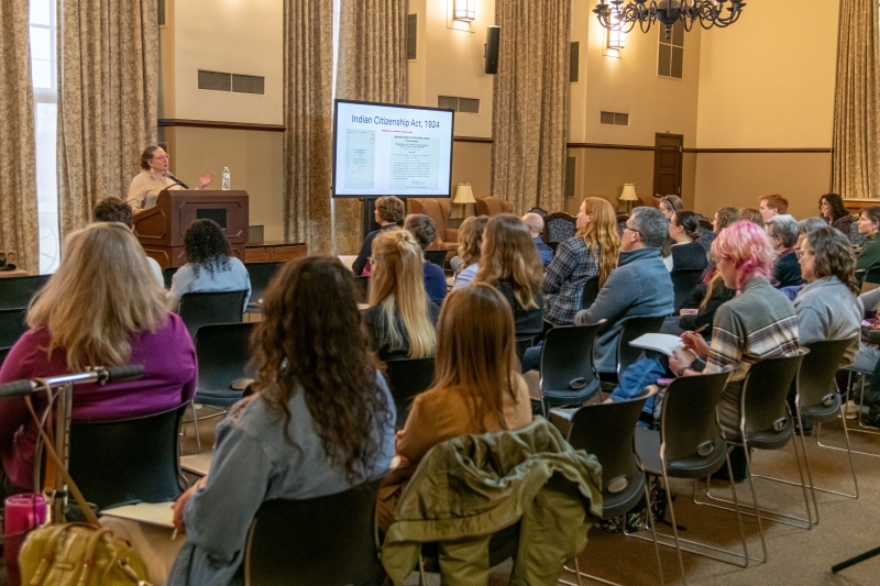 goeman at a podium in front of an audience goeman at a podium in front of an audience