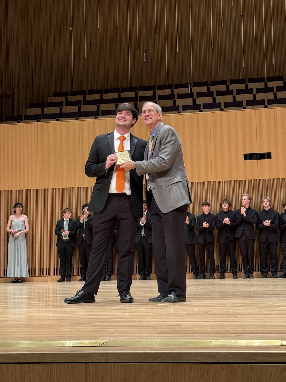 Man and student awardee posing for a picture on stage