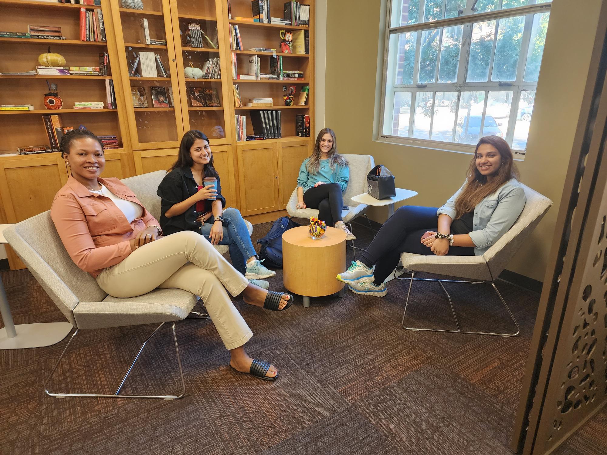 four diverse international students sitting in the center's library