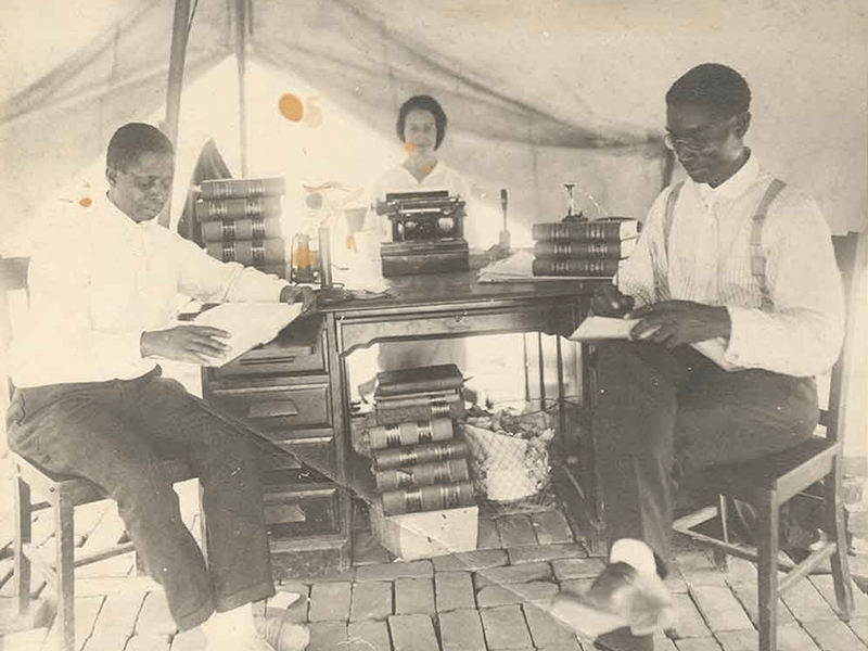 2 black men reading and 1 black woman typing