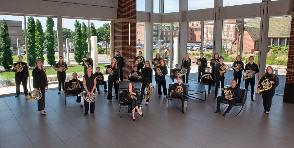 image of students posed in lobby holding French horns