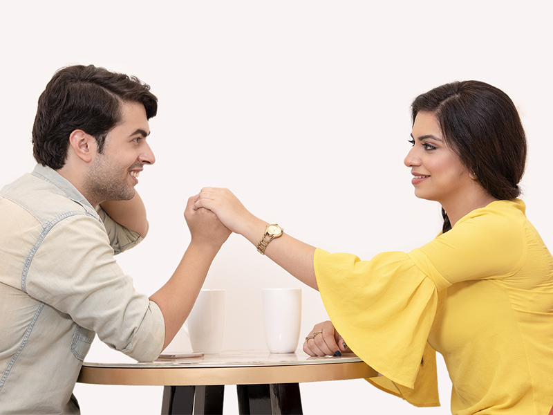 romantic partners holding hands across table