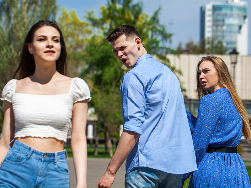 man holding hands with a woman while looking at another woman