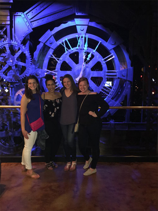 Four female students in front of a clock at the Society of Pediatric Psychology Annual Conference