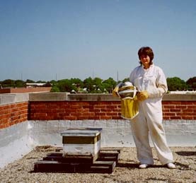 suit.jpg Woman posing in a protective bee collection suit