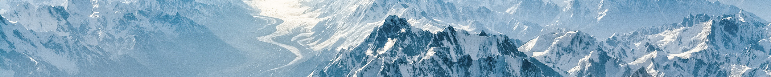 Snow-covered mountain range under a clear blue sky.