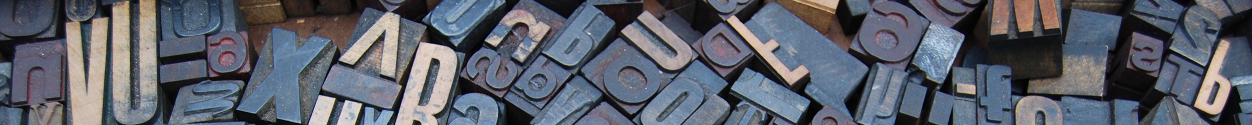 Collection of letterpress printing blocks with raised letters.